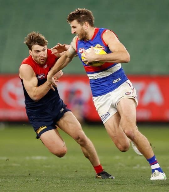 Marcus Bontempelli of the Bulldogs is chased by Jack Viney of the Demons during the 2021 AFL Round 19 match between the Melbourne Demons and the...