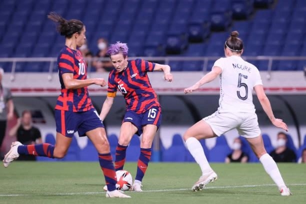 S forward Megan Rapinoe attempts a shot as she is marked by New Zealand's defender Meikayla Moore during the Tokyo 2020 Olympic Games women's group G...