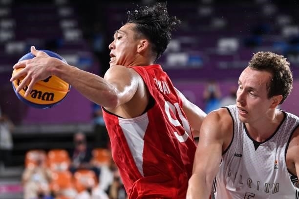 Japan's Tomoya Ochiai dribbles the ball past Belgium's Nick Celis during the men's first round 3x3 basketball match between Belgium and Japan at the...