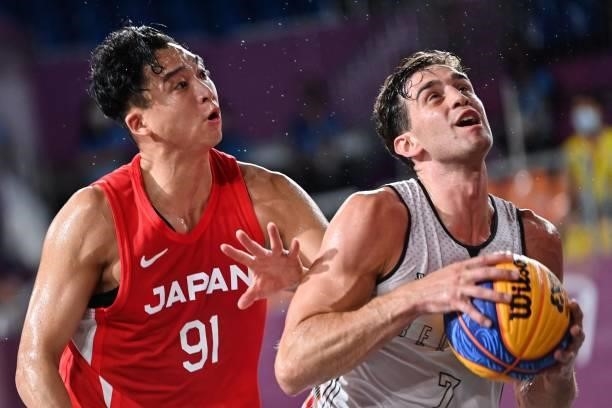 Japan's Tomoya Ochiai fights for the ball with Belgium's Rafael Bogaerts during the men's first round 3x3 basketball match between Belgium and Japan...