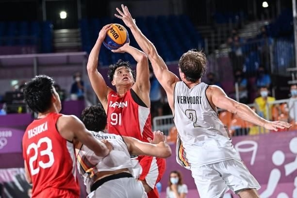 Japan's Tomoya Ochiai jumps to score past Belgium's Thibaut Vervoort during the men's first round 3x3 basketball match between Belgium and Japan at...