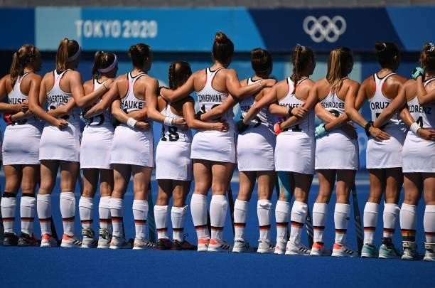 Players of Germany listen to their anthem before their women's pool A match of the Tokyo 2020 Olympic Games field hockey competition against Britain,...