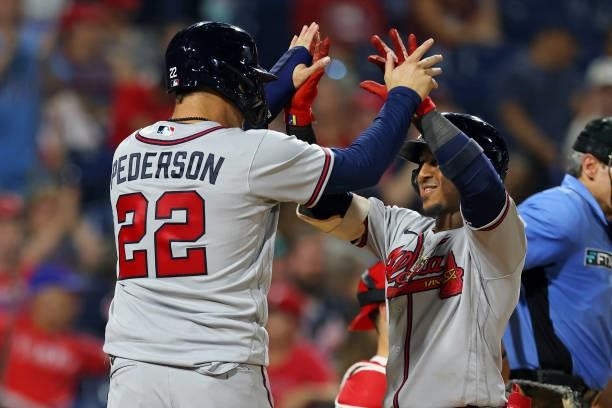 Ozzie Albies of the Atlanta Braves is congratulated by Joc Pederson after he hit a three-run home run during the eighth inning against the...