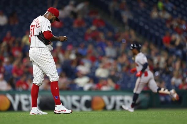 Pitcher Enyel De Los Santos of the Philadelphia Phillies looks down as Ozzie Albies of the Atlanta Braves rounds the bases after hitting a three-run...