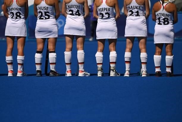 Players of Germany listen to their anthem before their women's pool A match of the Tokyo 2020 Olympic Games field hockey competition against Britain,...
