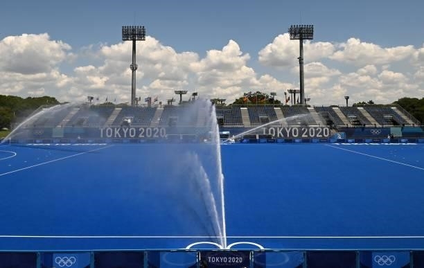 The South pitch of the Oi Hockey Stadium is watered before the start of the women's pool B match of the Tokyo 2020 Olympic Games field hockey...
