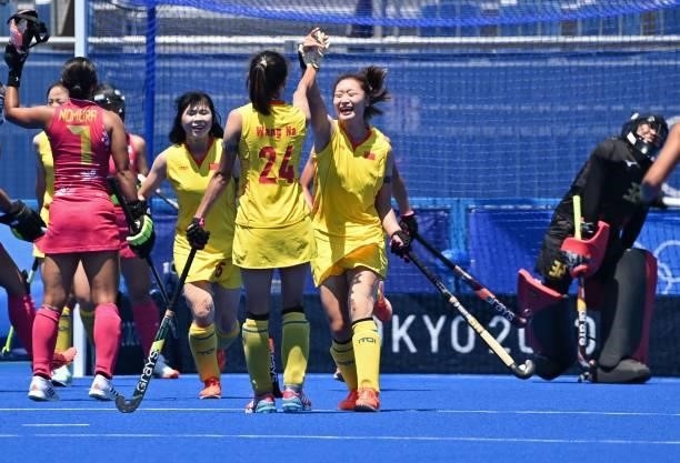 China's Zhang Ying celebrates with teammates after scoring against Japan during a penalty corner during their women's pool B match of the Tokyo 2020...