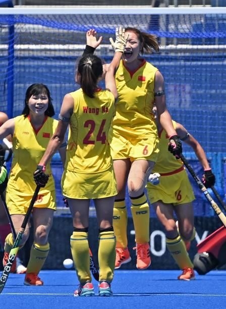 China's Zhang Ying celebrates with teammate Wang Na after scoring against Japan during a penalty corner during their women's pool B match of the...