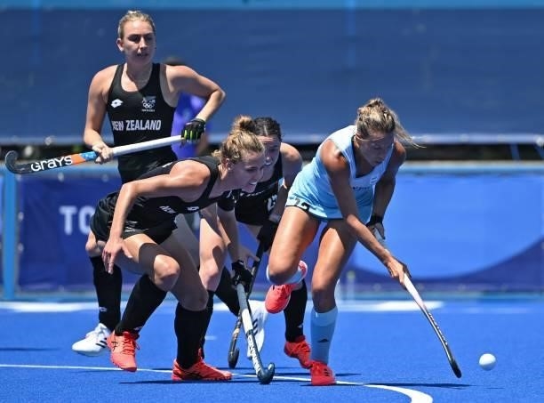 Argentina's Delfina Merino is marked by New Zealand's Frances Davies and Kelsey Smith during their women's pool B match of the Tokyo 2020 Olympic...