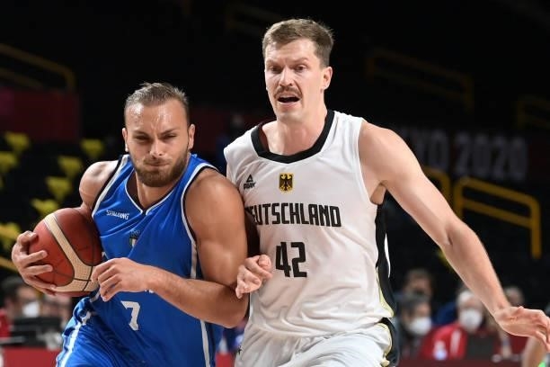 Italy's Stefano Tonut runs with the ball past Germany's Andreas Obst in the men's preliminary round group B basketball match between Germany and...
