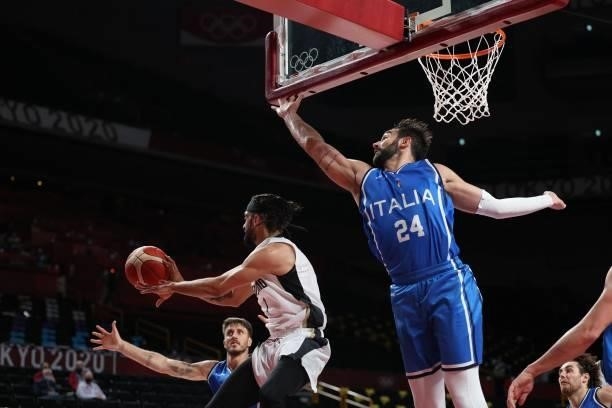 Germany's Joshiko Saibou catches the rebound as Italy's Riccardo Moraschini reacts in the men's preliminary round group B basketball match between...