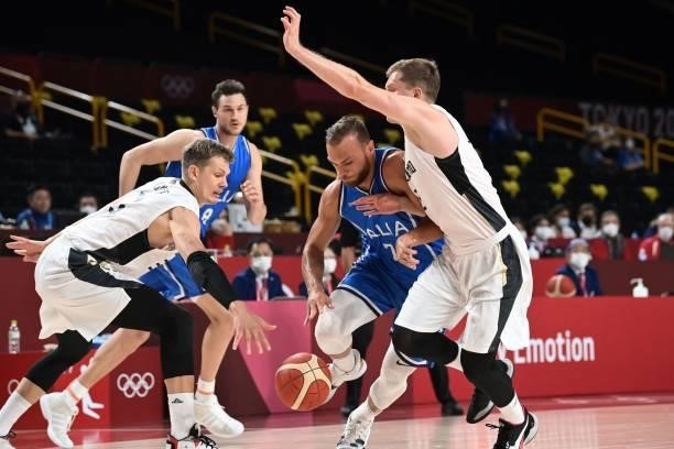 Italy's Nicolo Melli dribbles the ball past German players in the men's preliminary round group B basketball match between Germany and Italy during...