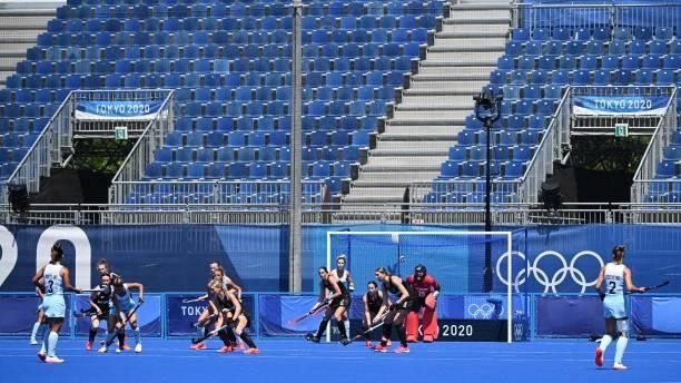 Empty spectator seats are seen during the women's pool B match of the Tokyo 2020 Olympic Games field hockey competition between New Zealand and...