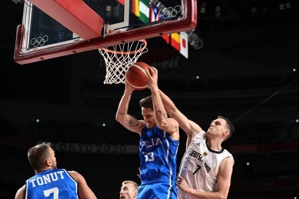 Italy's Achille Polonara and Germany's Johannes Voigtmann fight for the rebound in the men's preliminary round group B basketball match between...