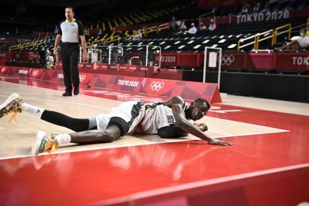 Germany's Isaac Bonga falls on the court in the men's preliminary round group B basketball match between Germany and Italy during the Tokyo 2020...