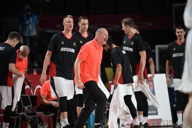 Germany's team coach Henrik Roedl along with players celebrate a point in the men's preliminary round group B basketball match between Germany and...