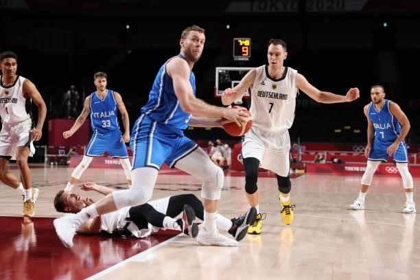 Italy's Nicolo Melli handles the ball as Germany's Johannes Voigtmann watches in the men's preliminary round group B basketball match between Germany...