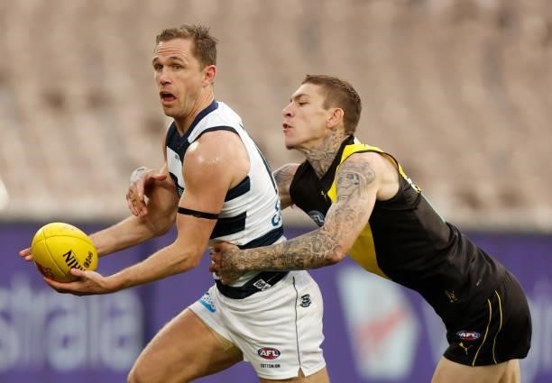 Joel Selwood of the Cats is tackled by Matthew Parker of the Tigers during the 2021 AFL Round 19 match between the Geelong Cats and the Richmond...