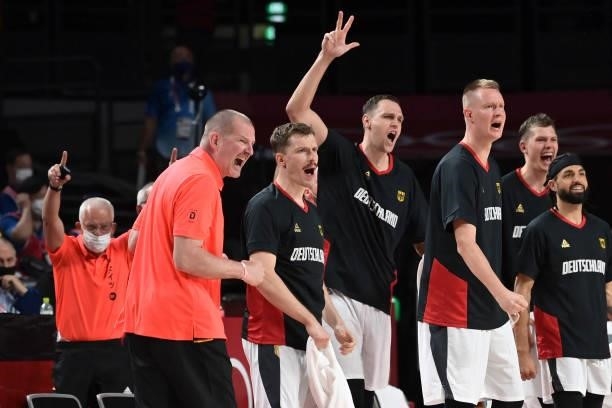 Germany's team coach Henrik Roedl along with players celebrate a point in the men's preliminary round group B basketball match between Germany and...