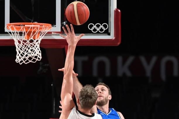 Italy's Nicolo Melli and Germany's Andreas Obst jumps for the rebound in the men's preliminary round group B basketball match between Germany and...