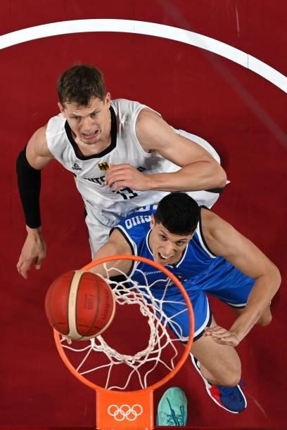 Italy's Simone Fontecchio scores a basket as Germany's Moritz Wagner watches in the men's preliminary round group B basketball match between Germany...