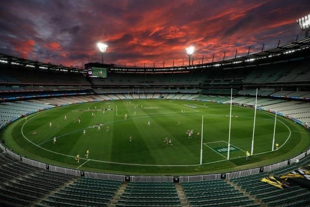 General view as the sun sets during the 2021 AFL Round 19 match between the Geelong Cats and the Richmond Tigers at the Melbourne Cricket Ground on...