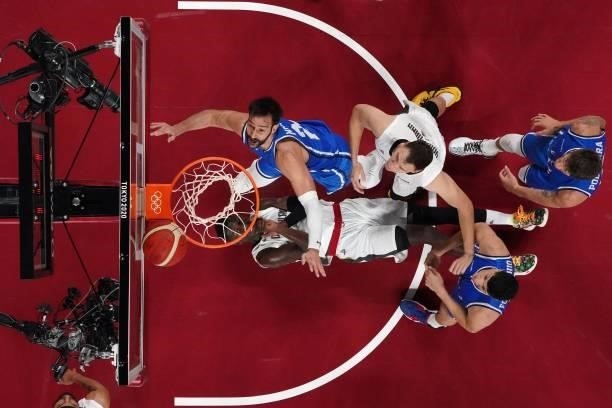 Germany's Isaac Bonga falls on the court as his teammate and Italian players fight for the rebound in the men's preliminary round group B basketball...