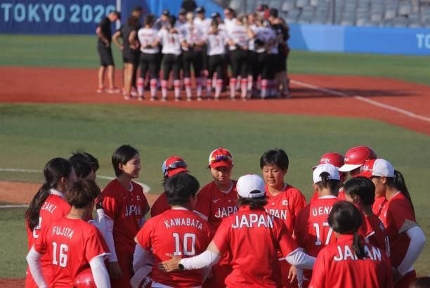 Japan and Canada's softball players and coaches gather after the Tokyo 2020 Olympic Games softball opening round game between Canada and Japan at...