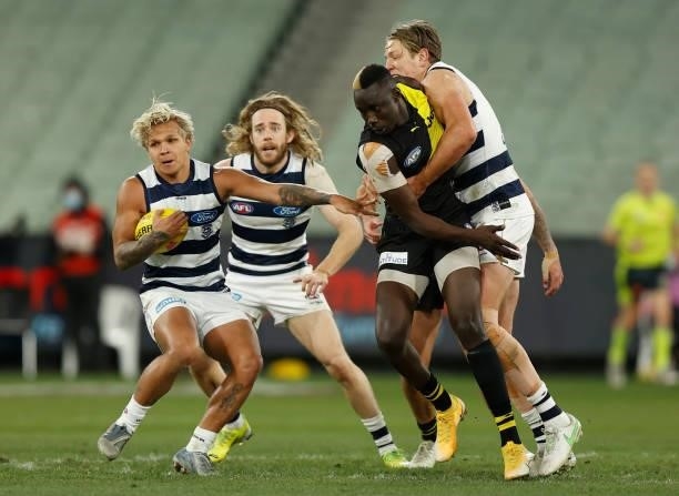 Quinton Narkle of the Cats fends of Mabior Chol of the Tigers during the 2021 AFL Round 19 match between the Geelong Cats and the Richmond Tigers at...