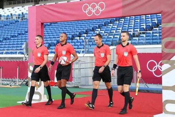 Match officials walk onto the pitch before the start of the Tokyo 2020 Olympic Games men's group D first round football match between Brazil and...