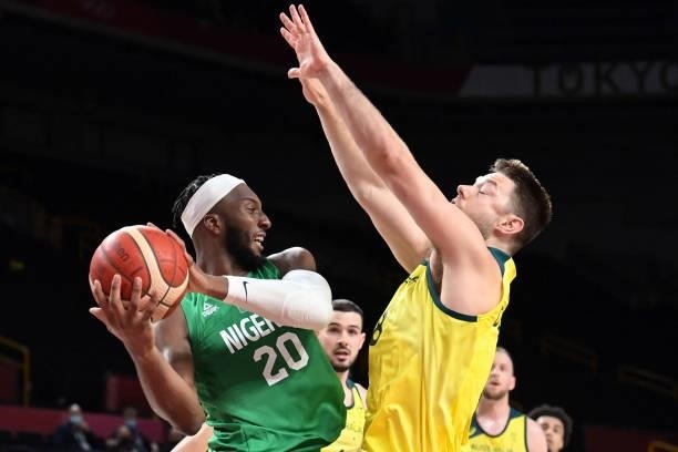 Nigeria's Josh Okogie tries to pass the ball in the men's preliminary round group B basketball match between Australia and Nigeria during the Tokyo...