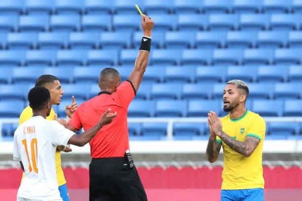 Referee Ismail Elfath shows a yellow card to Brazil's midfielder Douglas Luiz during the Tokyo 2020 Olympic Games men's group D first round football...