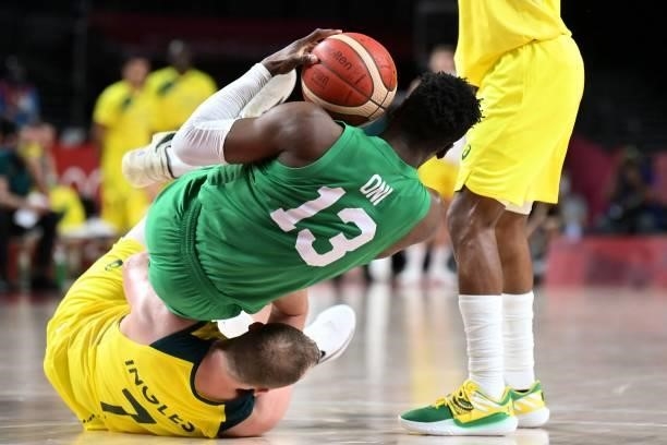 Australia's Joe Ingles and Nigeria's Olumiye Oni fall on the court in the men's preliminary round group B basketball match between Australia and...