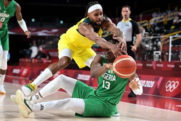 Australia's Patty Mills and Nigeria's Olumiye Oni fight for the ball in the men's preliminary round group B basketball match between Australia and...