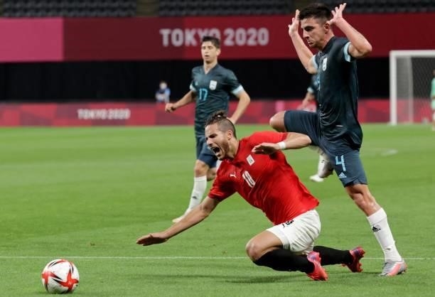 Egypt's forward Ramadan Sobhi falls on the pitch beside Argentina's defender Hernan De La Fuente during the Tokyo 2020 Olympic Games men's group C...