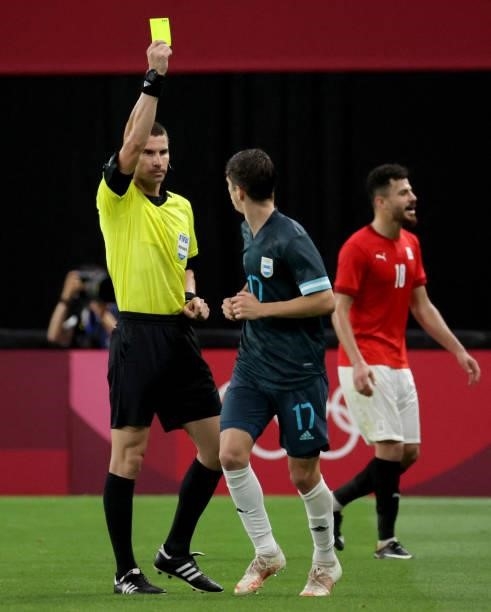 Referee Georgi Kabakov from Bulgaria displays a yellow card to Argentina's midfielder Tomas Belmonte during the Tokyo 2020 Olympic Games men's group...
