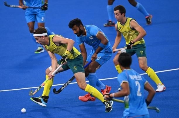 Australia's Flynn Andrew Ogilvie is challenged by India's Surender Kumar during their men's pool A match of the Tokyo 2020 Olympic Games field hockey...