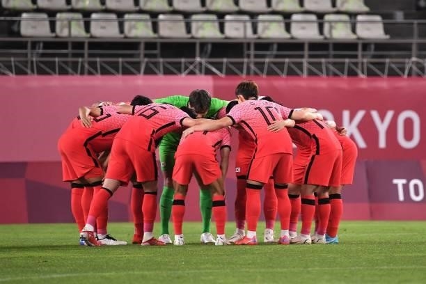 South Korea players gather in a huddle before the start of the Tokyo 2020 Olympic Games men's group B first round football match between Romania and...
