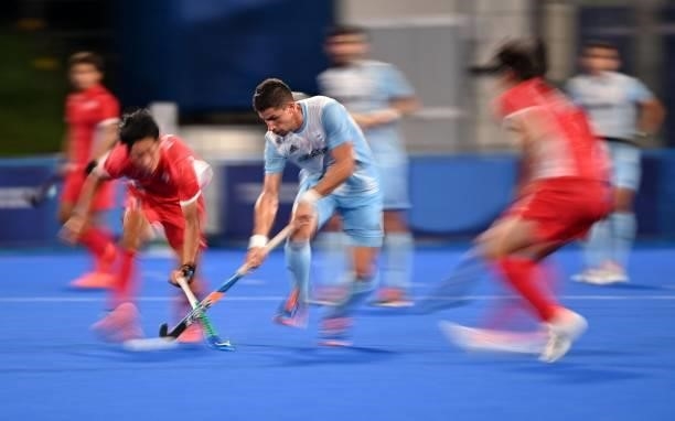 Argentina's Santiago Tomas Tarazona is marked by players of Japan during their men's pool A match of the Tokyo 2020 Olympic Games field hockey...