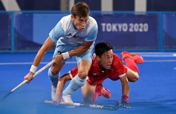 Argentina's Lucas Martinez and Japan's Yoshiki Kirishita vie during their men's pool A match of the Tokyo 2020 Olympic Games field hockey...