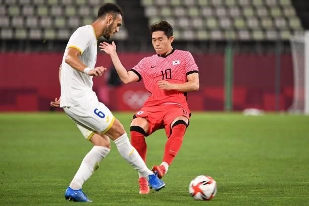 Romania's defender Virgil Ghita fights for the ball with South Korea's midfielder Lee Dong-gyeong during the Tokyo 2020 Olympic Games men's group B...