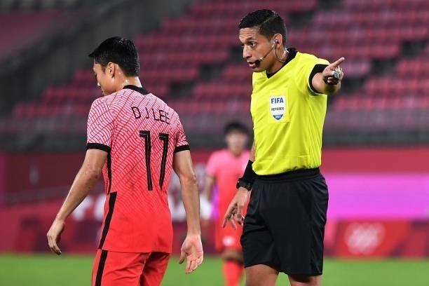 Venezuela referee Jesus Valenzuela gestures as he talks with South Korea's forward Lee Dong-jun during the Tokyo 2020 Olympic Games men's group B...
