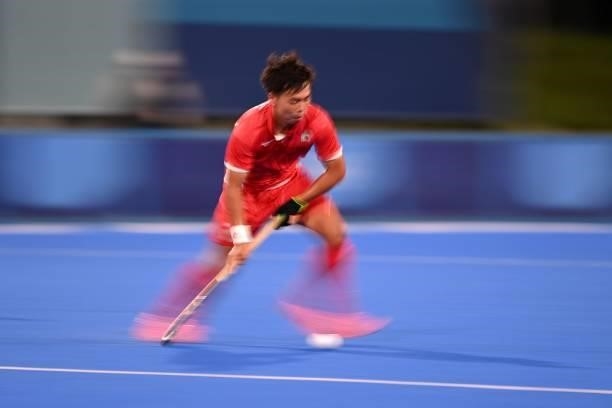 Japan's Hirotaka Zendana carries the ball during the men's pool A match of the Tokyo 2020 Olympic Games field hockey competition against Argentina,...