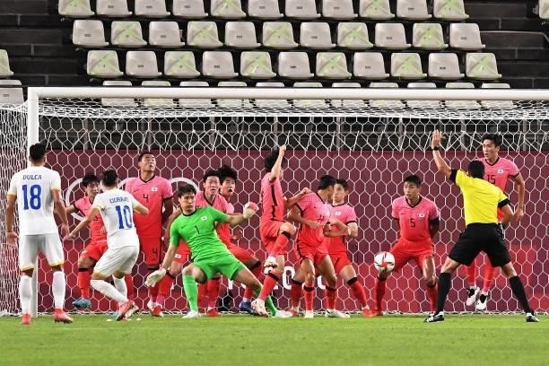Romania's midfielder Andrei Ciobanu takes a free kick but fails to score during the Tokyo 2020 Olympic Games men's group B first round football match...