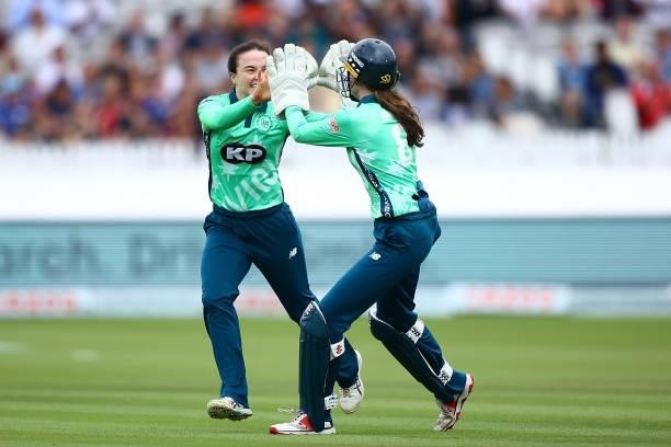 Mady Villiers of the Oval Invincibles celebrates with team mate Sarah Bryce after dismissing Deandra Dottin of London Spirit during the Hundred match...