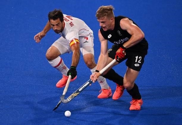 Spain's Miguel Delas De Andres and New Zealand's Sam Lane vie for the ball during their men's pool A match of the Tokyo 2020 Olympic Games field...