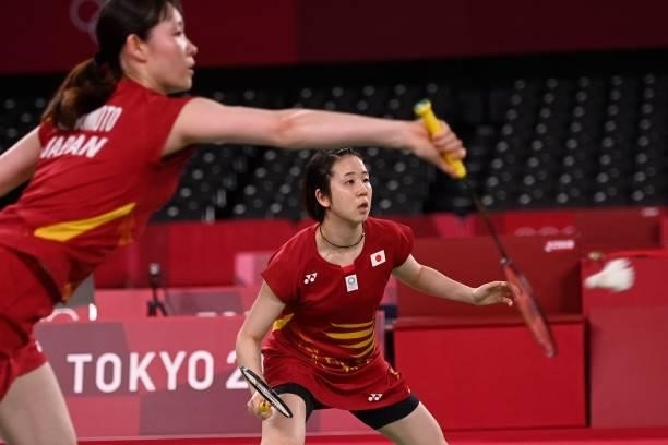 Japan's Wakana Nagahara watches as Japan's Mayu Matsumoto hits a shot in their women's doubles badminton group stage match against Canada's Kristen...