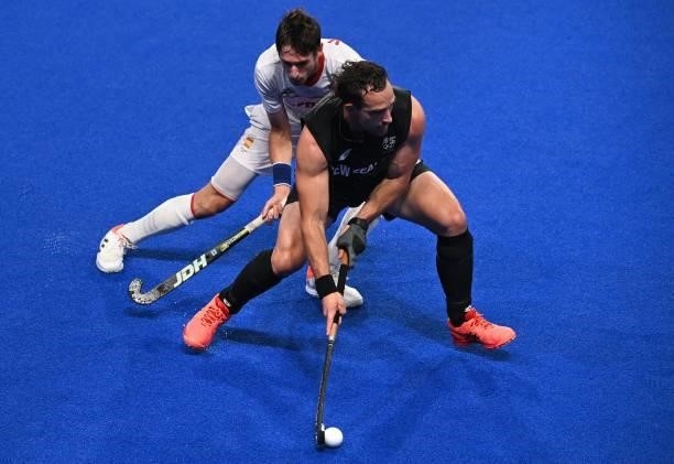 Spain's Vicenc Ruiz challenges New Zealand's Dane Lett during their men's pool A match of the Tokyo 2020 Olympic Games field hockey competition, at...