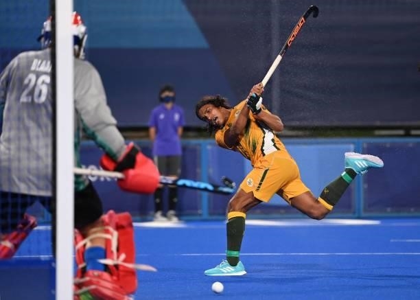 South Africa's Mustaphaa Cassiem strikes the ball during the men's pool B match of the Tokyo 2020 Olympic Games field hockey competition against...