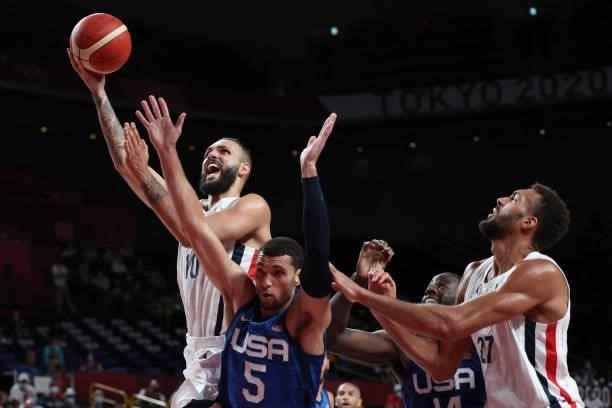 France's Evan Fournier goes to the basket as USA's Zachary Lavine watches in the men's preliminary round group A basketball match between France and...